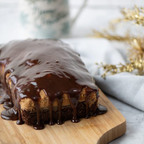 Chocolate Coffee Loaf Cake on a wooden bread chopping board drizzled with chocolate.