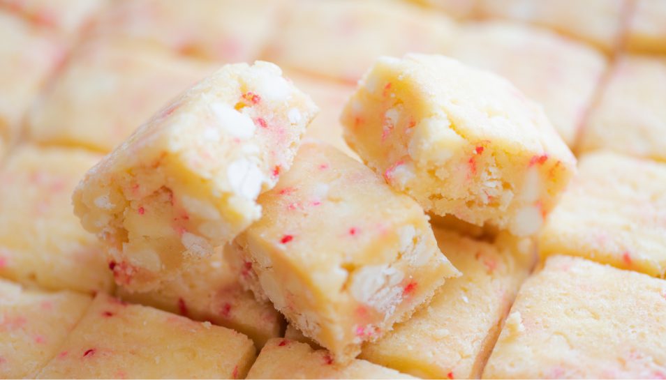 White chocolate and strawberry cake batter bites sliced into small pieces.